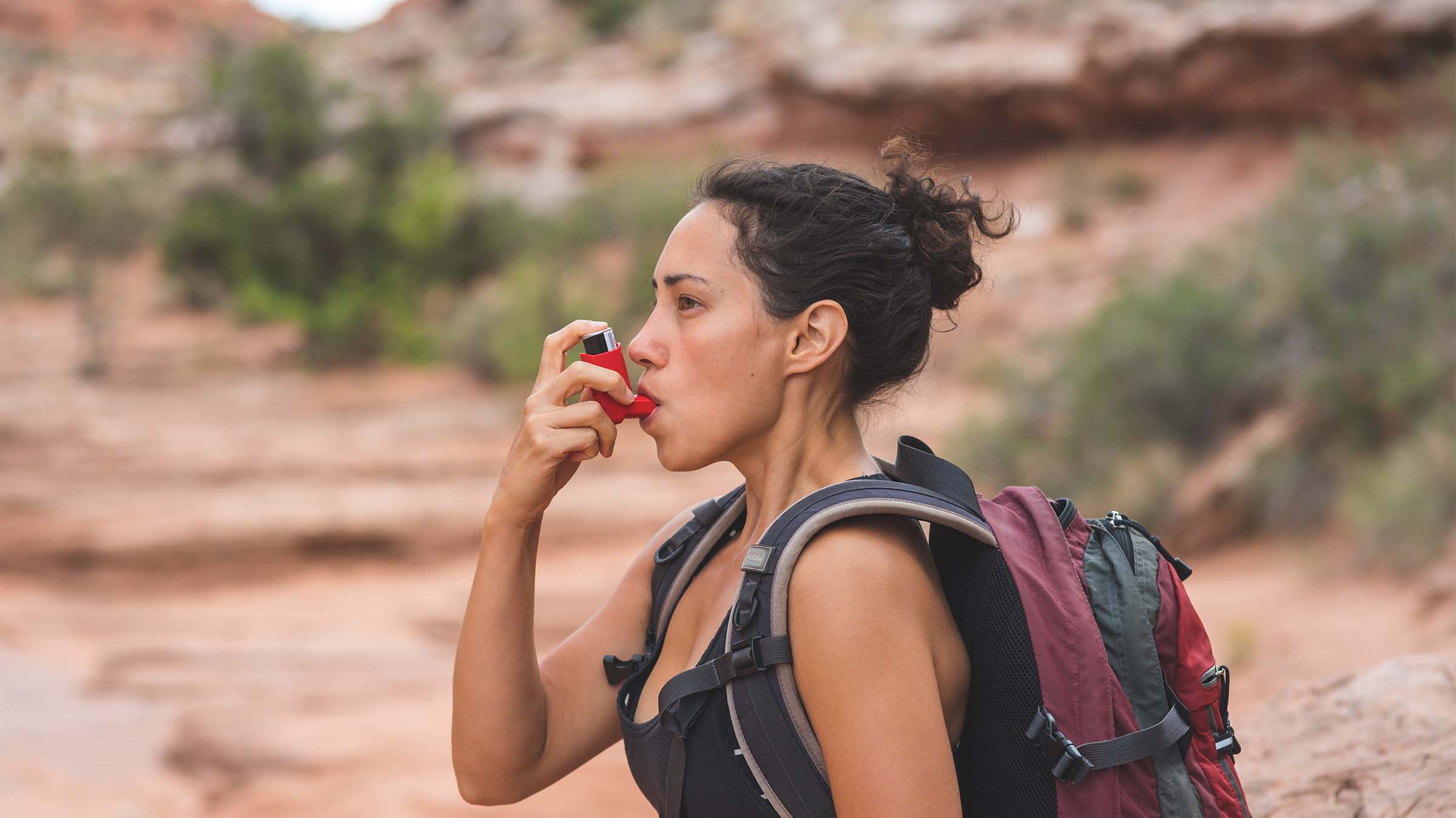 woman taking inhaler