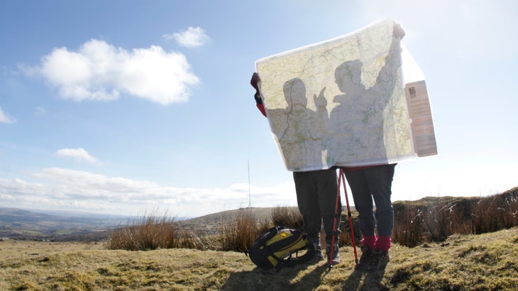 two hikers looking at map