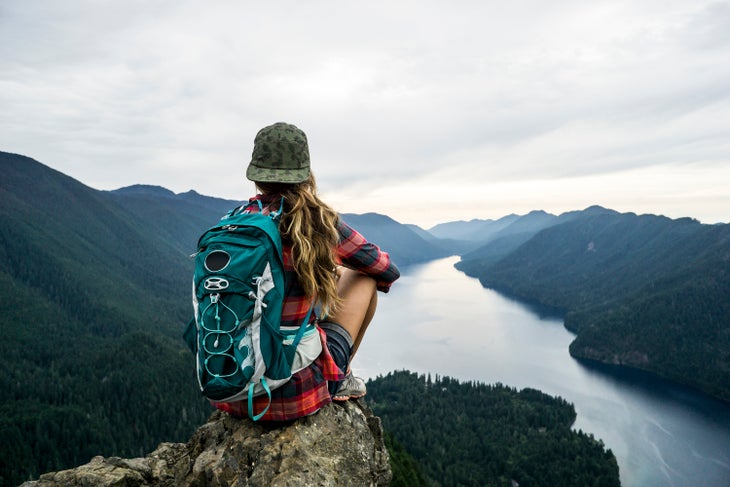 woman sitting over lake with backpack