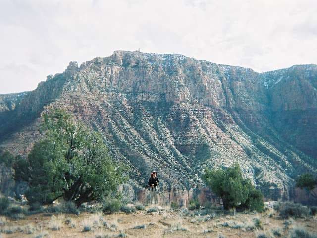Hiker stands in front of 75-mile Saddle along the Tanner Trail in Grand Canyon National Park. 