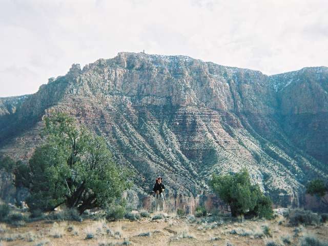 Hiker stands in front of 75-mile Saddle along the Tanner Trail in Grand Canyon National Park. 