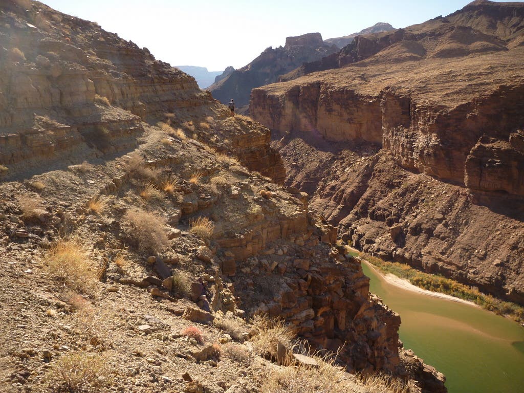 Views from the Beamer Trail in Grand Canyon National Park. Hiker skirting the edge of the canyon as they traverse the Beamer Trail toward Little Colorado River.