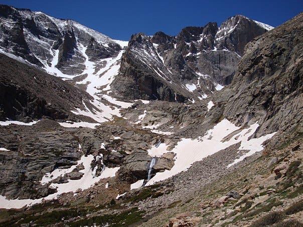Columbine Falls And Longs Peak as seen on the hike to Chasm Lake. A view from the Chasm Lake Trail of Columbine Falls and Longs Peak dotted with snow.