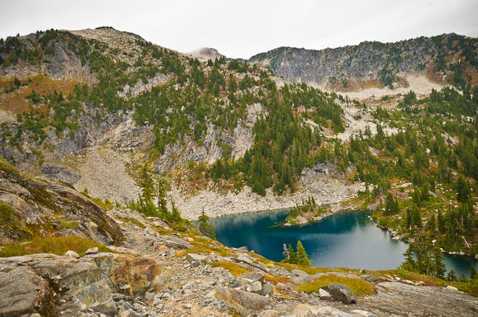 Copper Lake sits partway along the hike between Copper Ridge and Beaver Trail. The blue waters of Copper Lake sparkle up from the middle of green pines and mountainous shores.