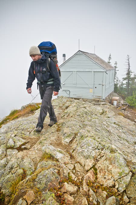 A hiker steps across the rocky top of the Copper Ridge Lookout Tower. 