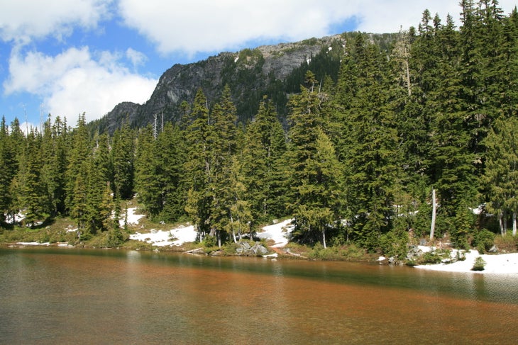 The shores of Emerald Lake with Flattop Mountain and Hallet Peak towering over it. 