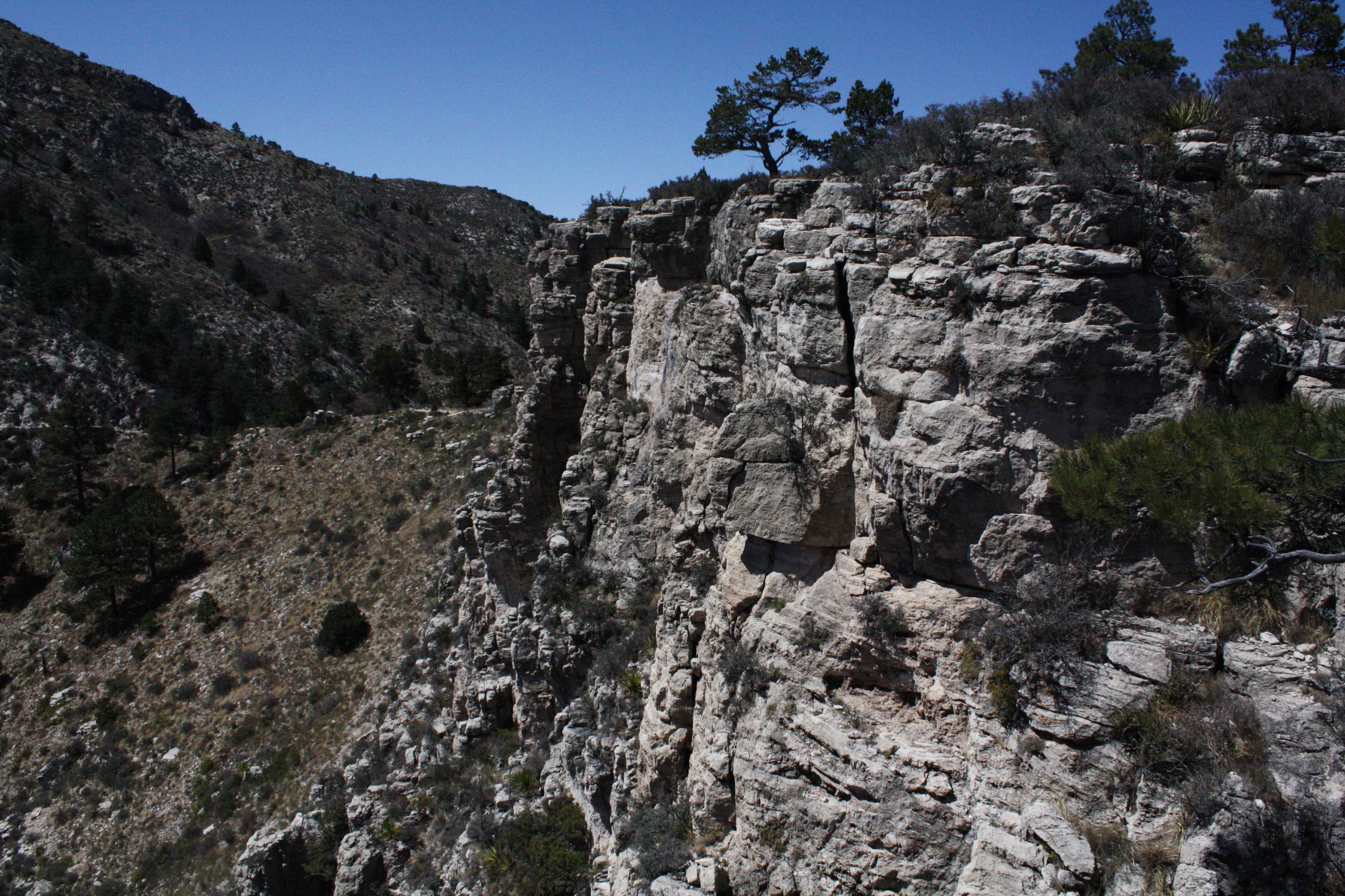 Guadalupe National Park views from the backcountry campground near the summit of Guadalupe Peak. Craggy cliffs under a blue sky in the Guadalupe Mountains National Park.