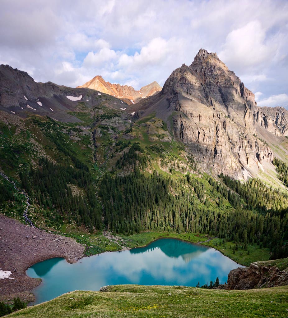 The sharp peaks of Mount Sneffels proudly stand watch above the turquoise waters of Lower Blue Lake.