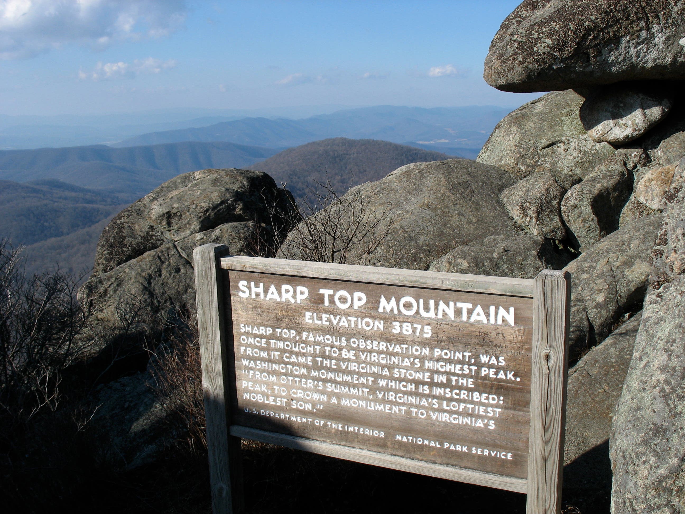 Wooden sign in a boulder field near the peak of Sharp Top Mountain. 