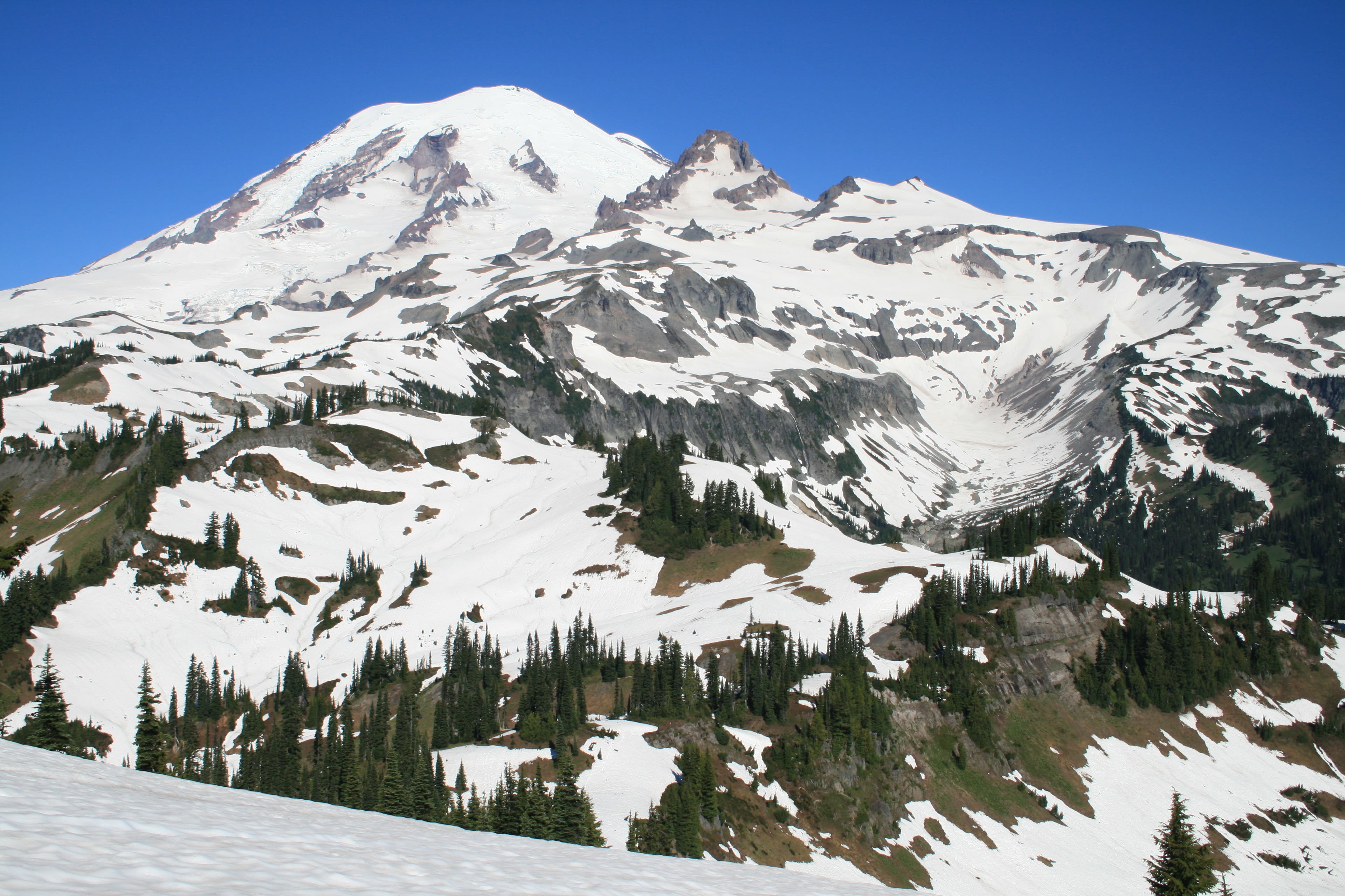 Views from the Cowlitz Divide along the Wonderland Trail show the snow-capped top of Mount Rainier looming in the distance. 