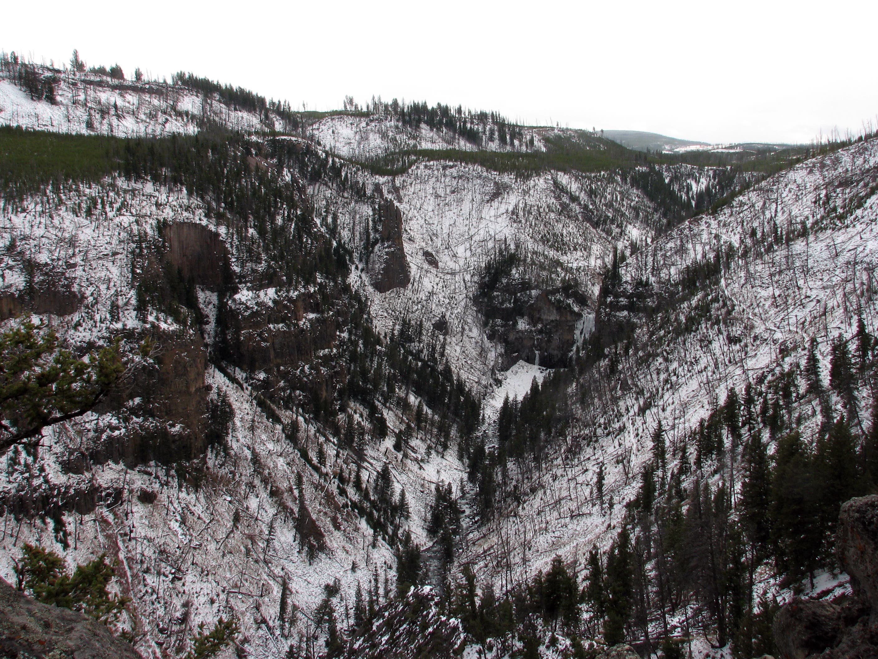 Views of a rocky, snow-covered ampitheater at the Flatirons Loop highpoint. 