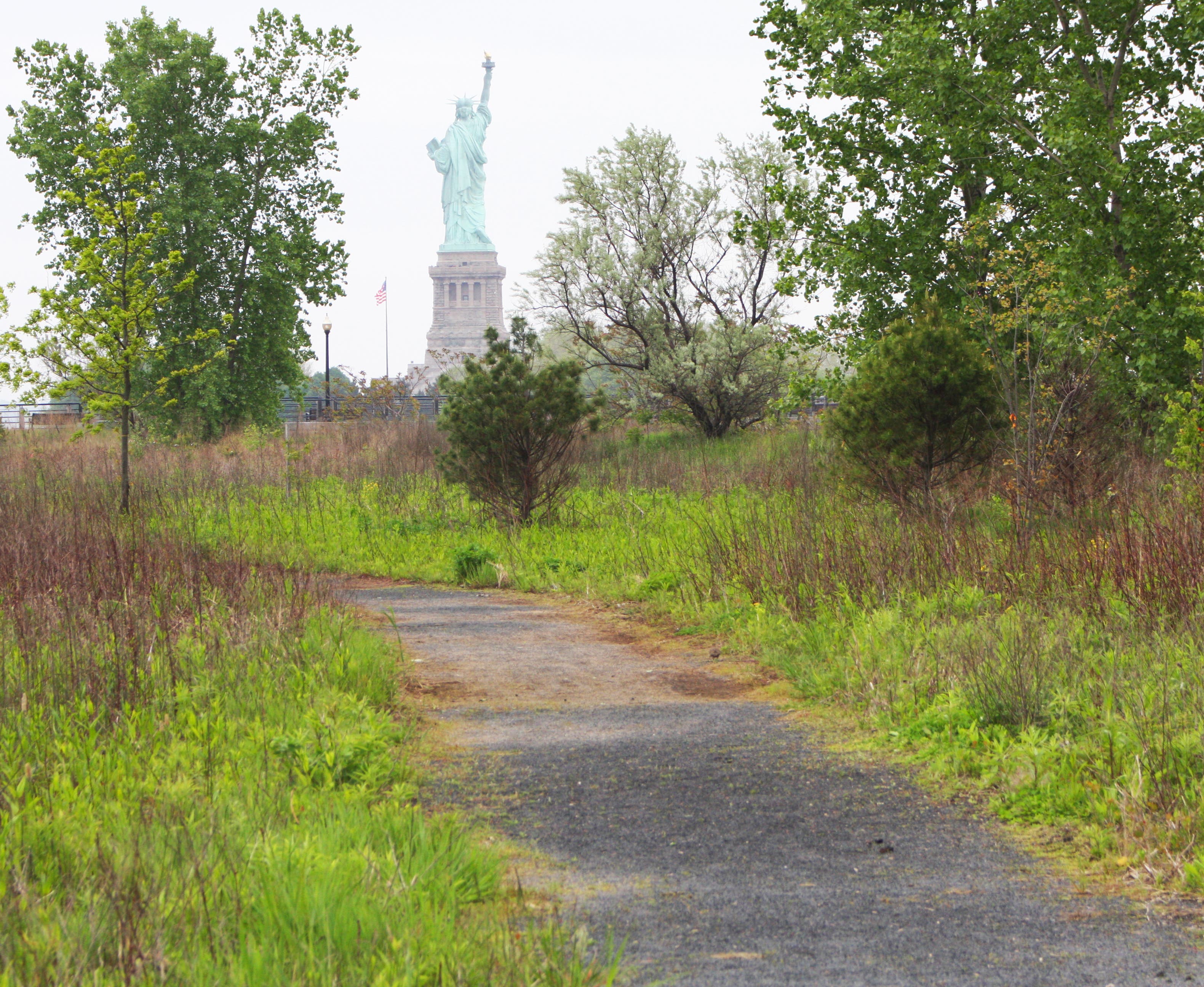 Path through natural area Liberty State Park: Multi-use trail and Statue of Liberty