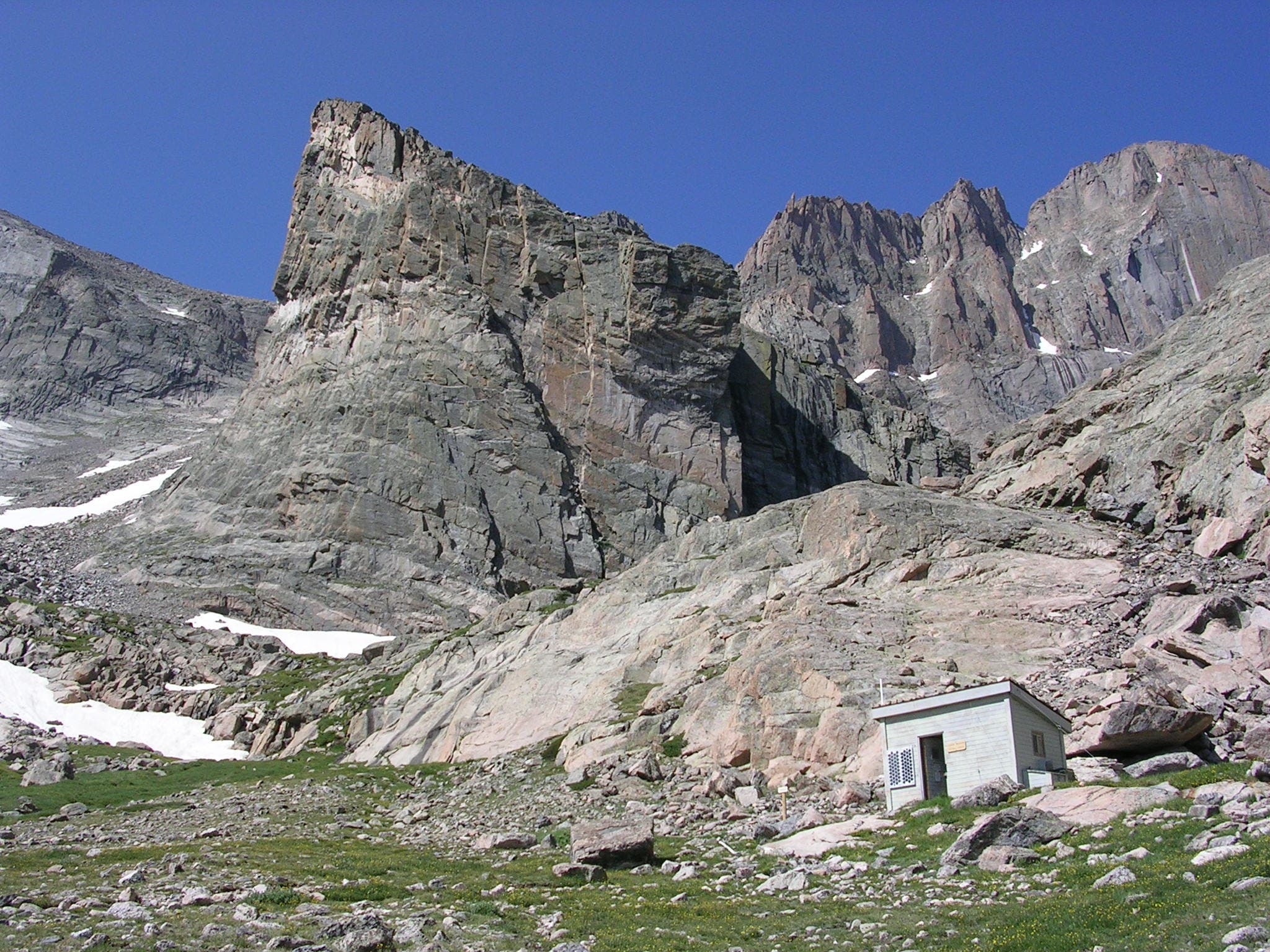 A patrol cabin along the Chasm Lake Trail sits in the shadow of the rock outcropping called the Ship's Prow. 