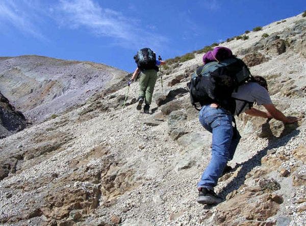 Class II scramble near the finish of the Chasm Lake Trail. Two hikers scramble up the rocky finish of the Chasm Lake Trail.