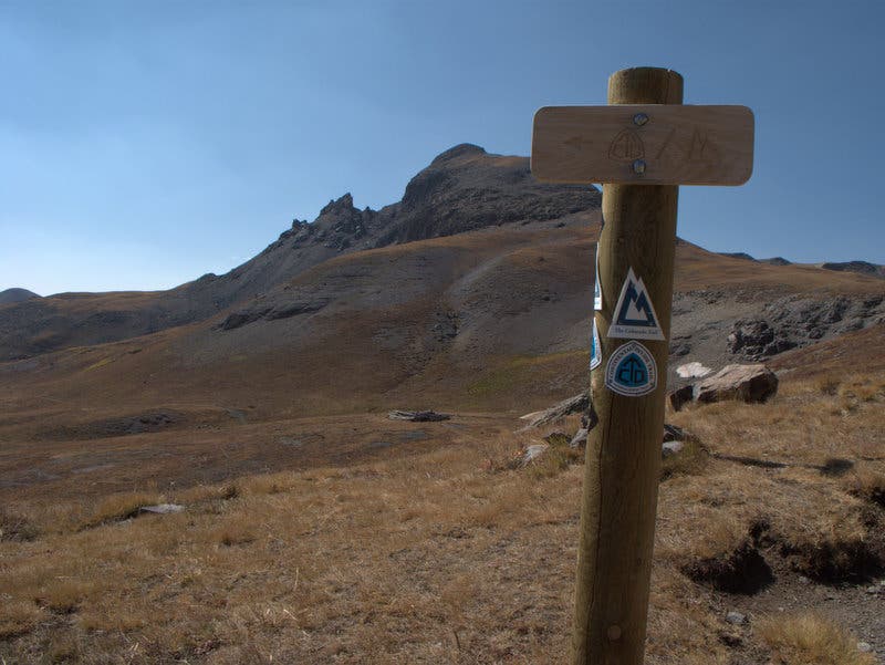 Trail sign for Colorado Trail and Continental Divide Trail at the beginning of the Colorado Trail section between Stony Pass and Celebration Lake. A wooden trail sign at the beginning of the Colorado Trail section between Stony Pass and Celebration Lake.