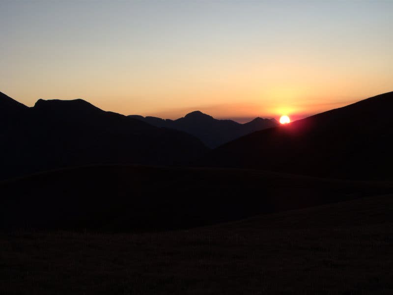 Sunset at 12,600 foot between Stony Pass and Celebration Lake on the Colorado Trail. The sun sinking behind shadowed mountains to end the day.