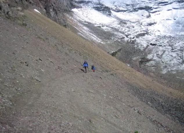 Talus slopes along the Bolder Pass Trail up to Kintla Lake. Two hikers on Bolder Pass Trail hiking through talus slopes.