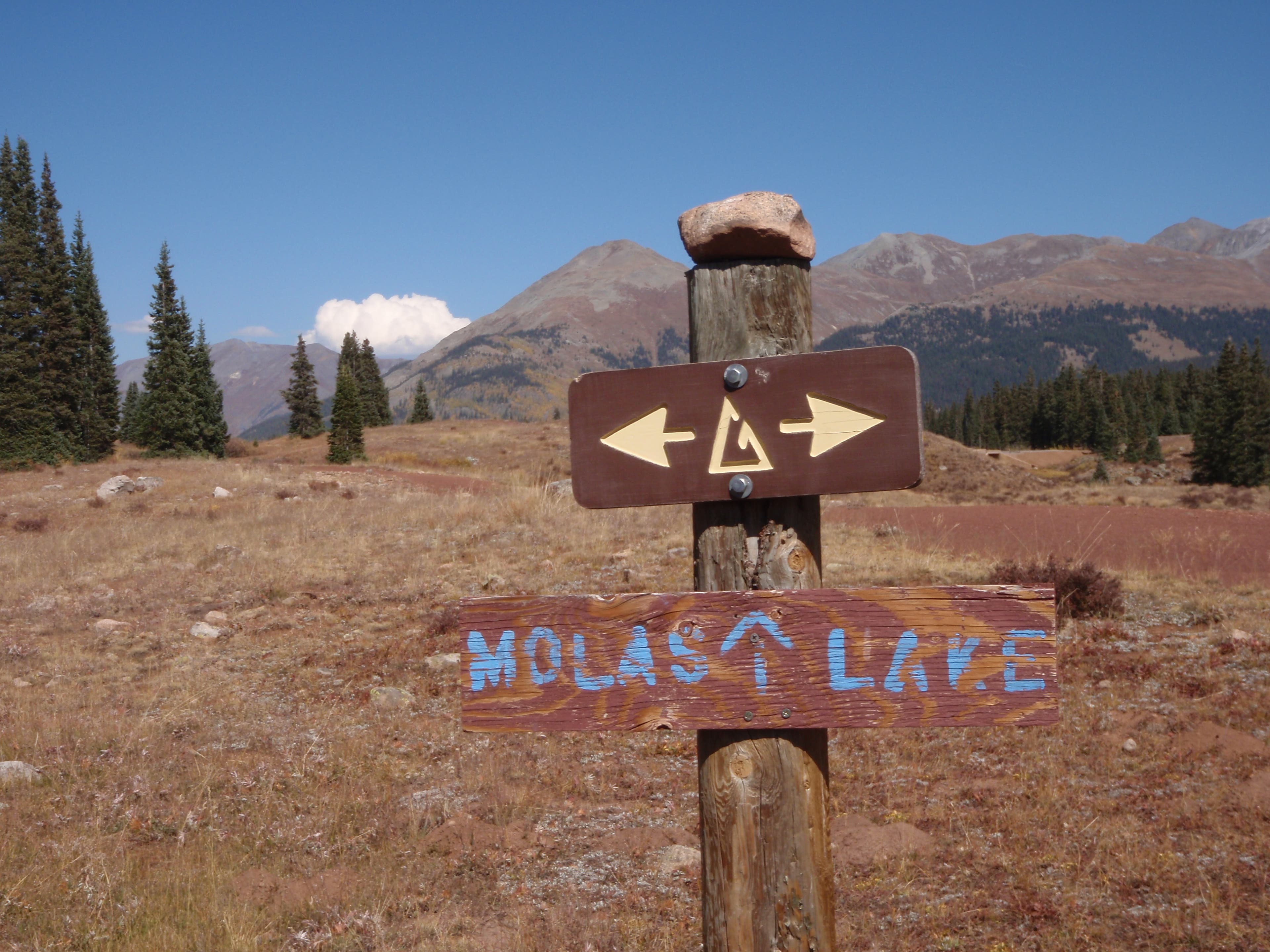 A wooden trail sign points the way to Molas Lake in the San Juans between Stony Pass and Celebration Lake. 