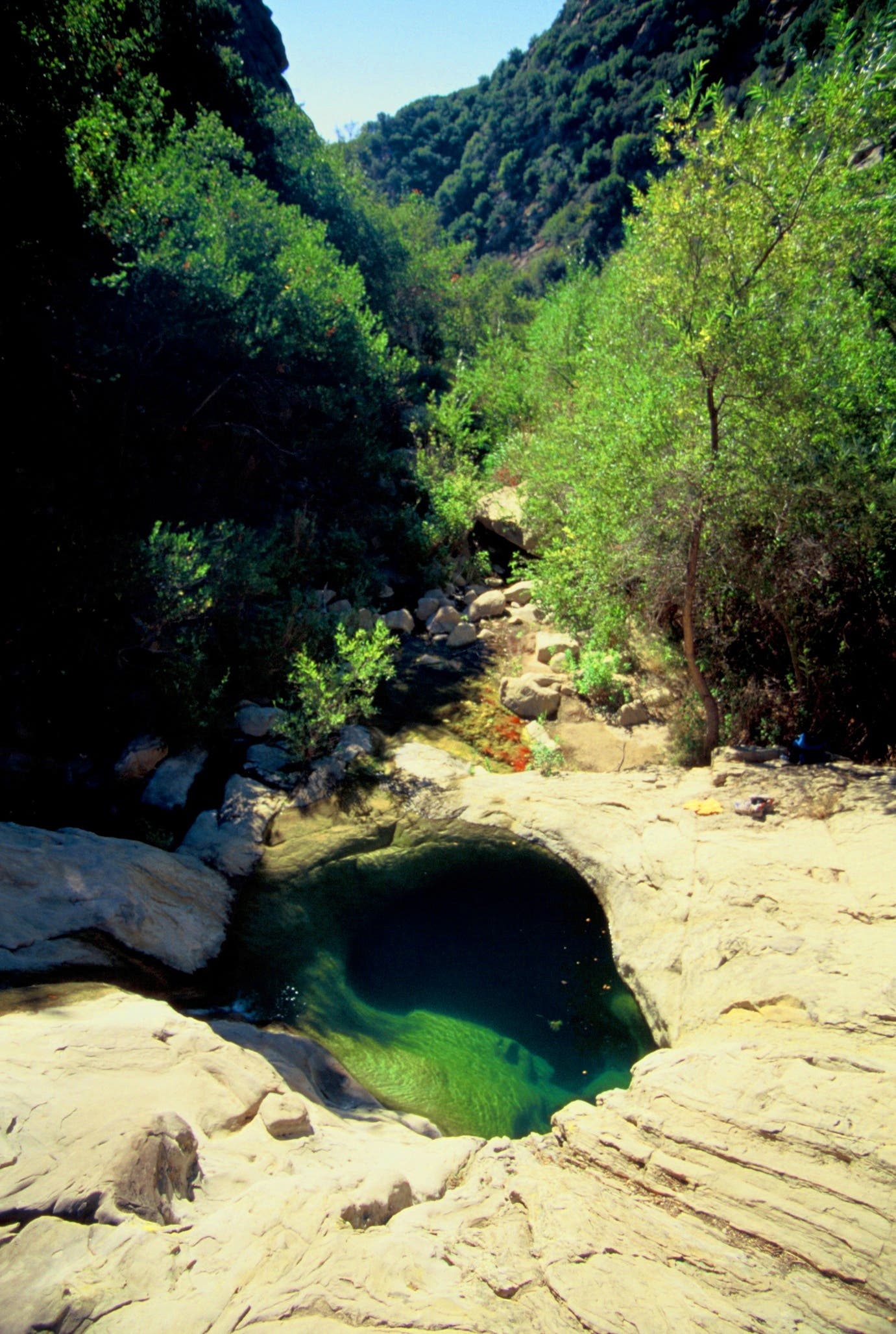 A small swimming hole with clear water nestled in the sandstone at Seven Falls. 