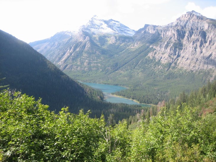 Views from the Bolder Pass Trail of Upper Kintla Lake. The turquoise waters of Upper Kintla Lake sparkle in the distance from views along the Bolder Pass Trail.