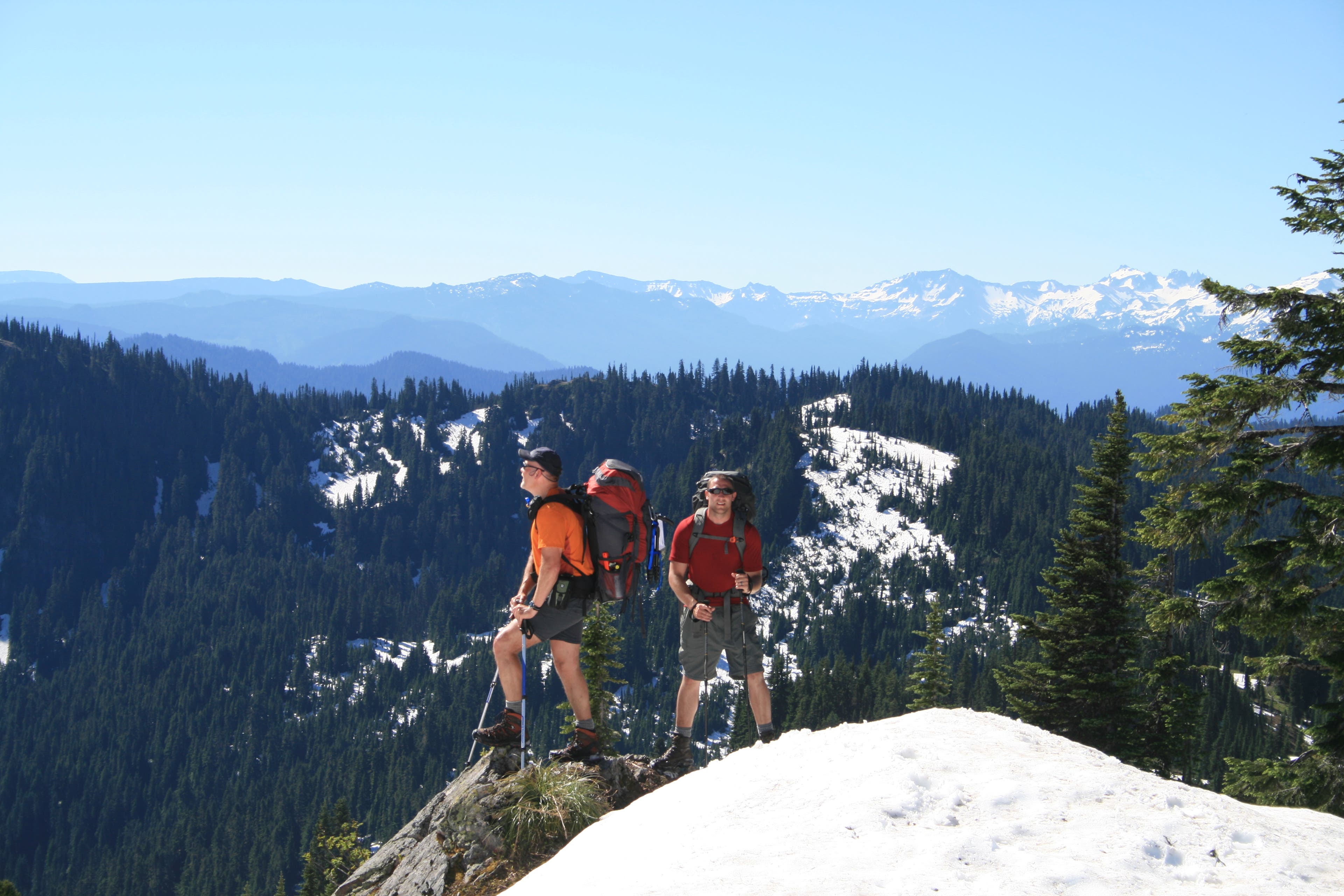 Views from the Cowlitz Divide in between Fryingpan Creek and Mowich Lake. Two hikers stopping to take in views from the Cowlitz Divide.
