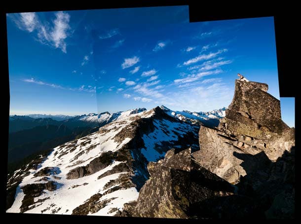 Perched on the rocky summit of Hidden Lake Peak, Stephen Byrne peers down into the depths of the Cascade River drainage. North Cascades National Park…