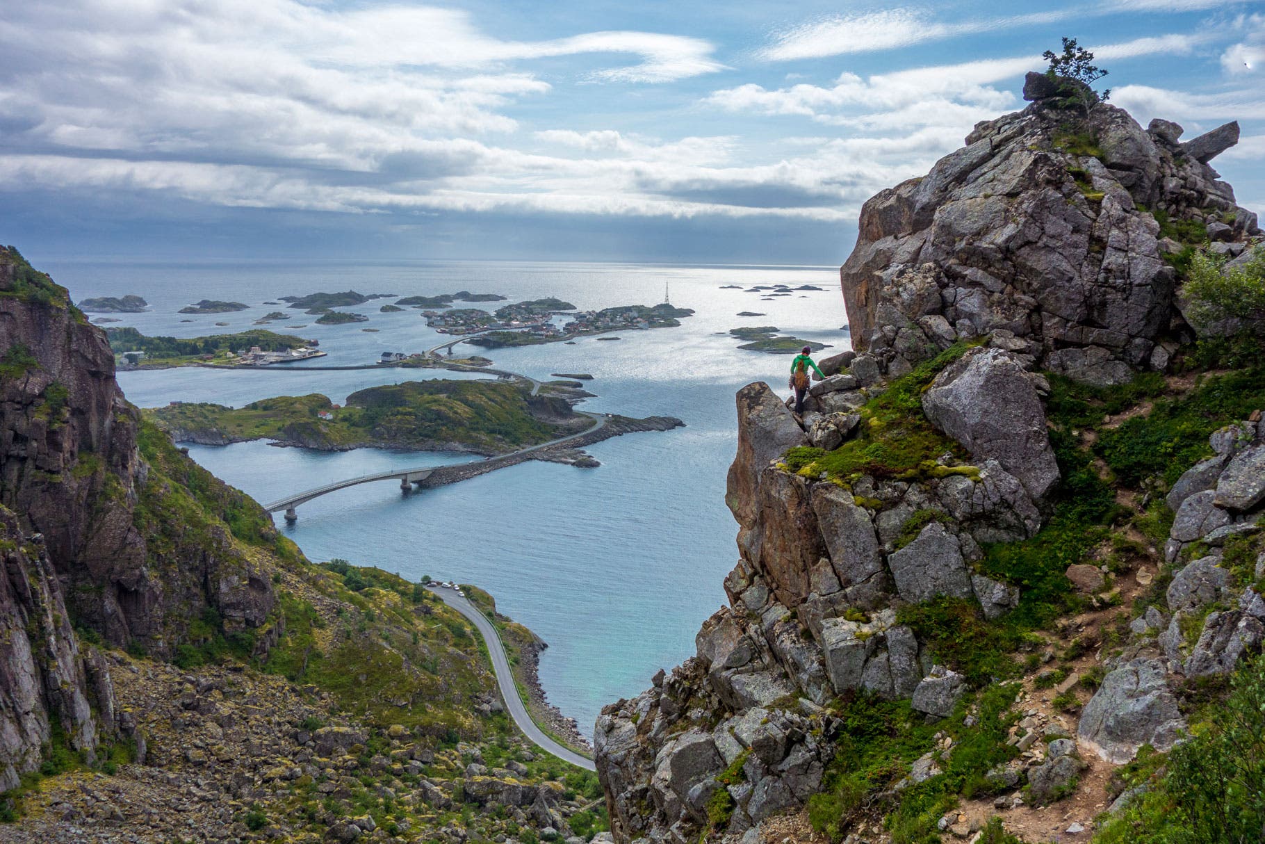 Author Majka Burhardt pauses between climbs on Festvag, with the bridges and islands connecting the island town of Henninsvaer laid out below.