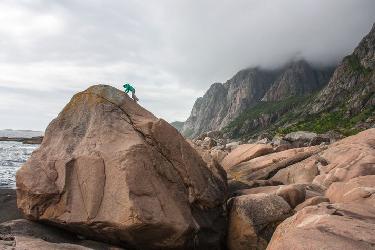 Norway: Paradiset Majka Burhardt explores where the granite meets the ocean on the shore of Paradiset with the mountains leading to Henninsvaer behind.