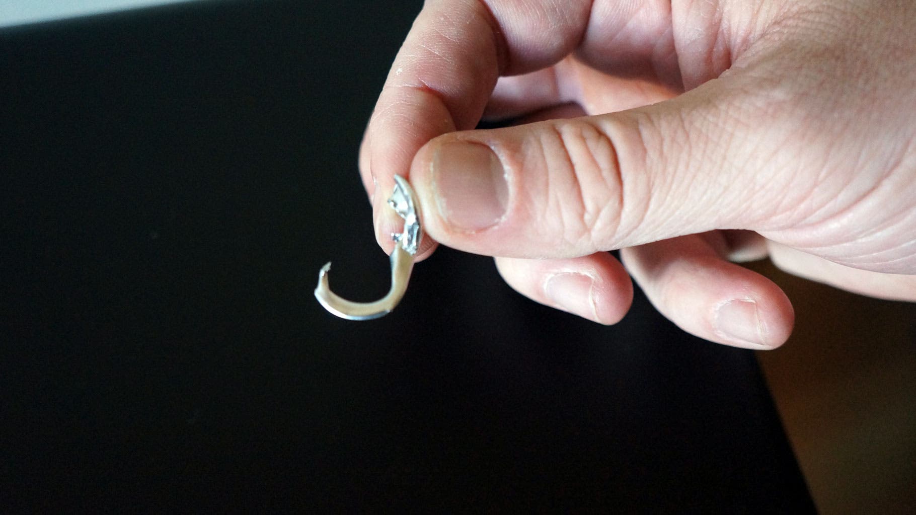 File or pinch the closed hole of your tab if it has sharp edges so it won’t saw through your line.