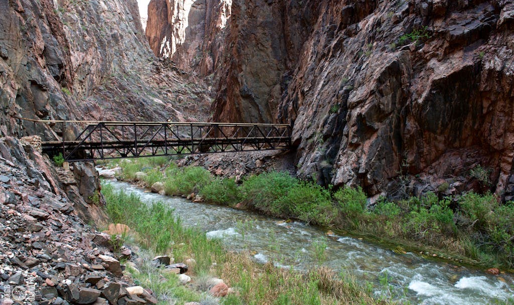The North Kaibab Trail replaces an older trail infamous for crossing Bright Angel Creek 94 times.  Hiker crosses the bridge over Bright Angel Creek…