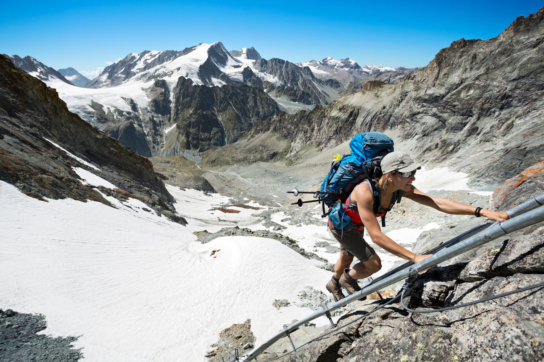 A woman hiker climbing a ladder to the Bertol Hut on the fourth day of the Chamonix to Zermatt Glacier Haute Route.