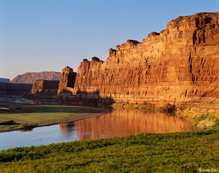 Downstream view at sunrise of the free-flowing Colorado River viewed from just below its confluence with the Dirty Devil River. When Lake Powell was…