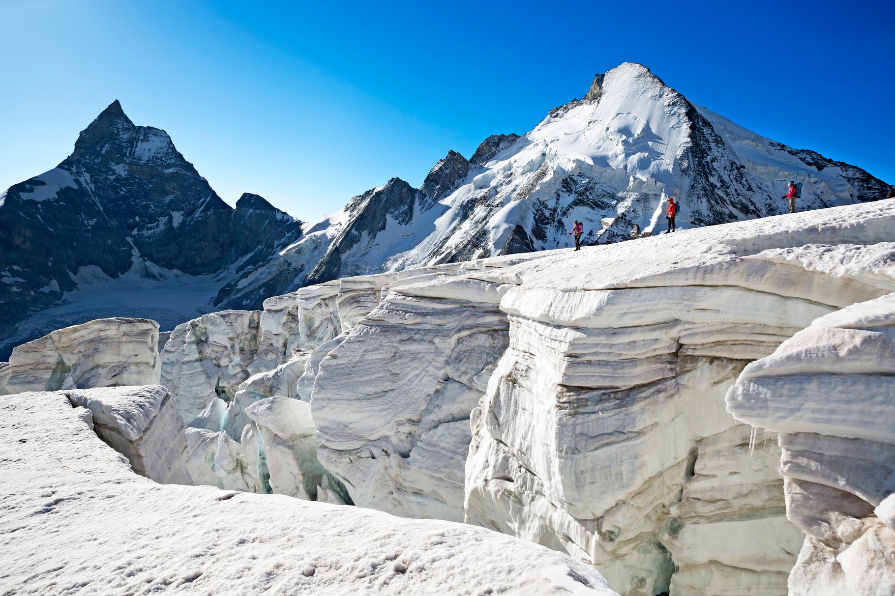 Hiking on a crevassed glacier A heavily crevassed and dangerous Stockjigletscher is the final descent on the fifth day of the Chamonix to Zermatt Glacier Haute Route. Great care…