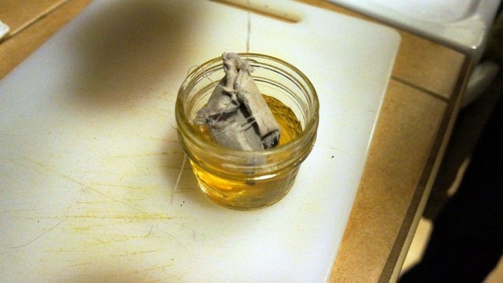 Make a Firestarter-Step 8 Once wax is melted (about 10 minutes), use floss to dip your lint-filled egg crate into the wax. Push it around with your finger if necessary to make…