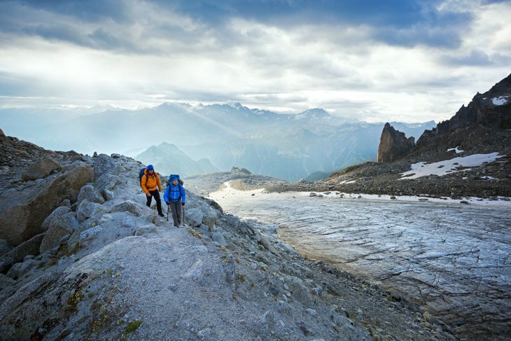 Glacier d'Orny Two hikers walking alongside the Glacier d'Orny on the first day of the Chamonix to Zermatt Glacier Haute Route.