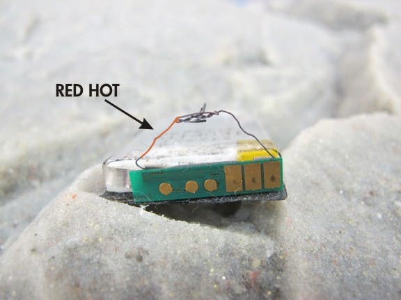 Short circuit the battery and create a red hot wire that will ignite good, dry tinder.
