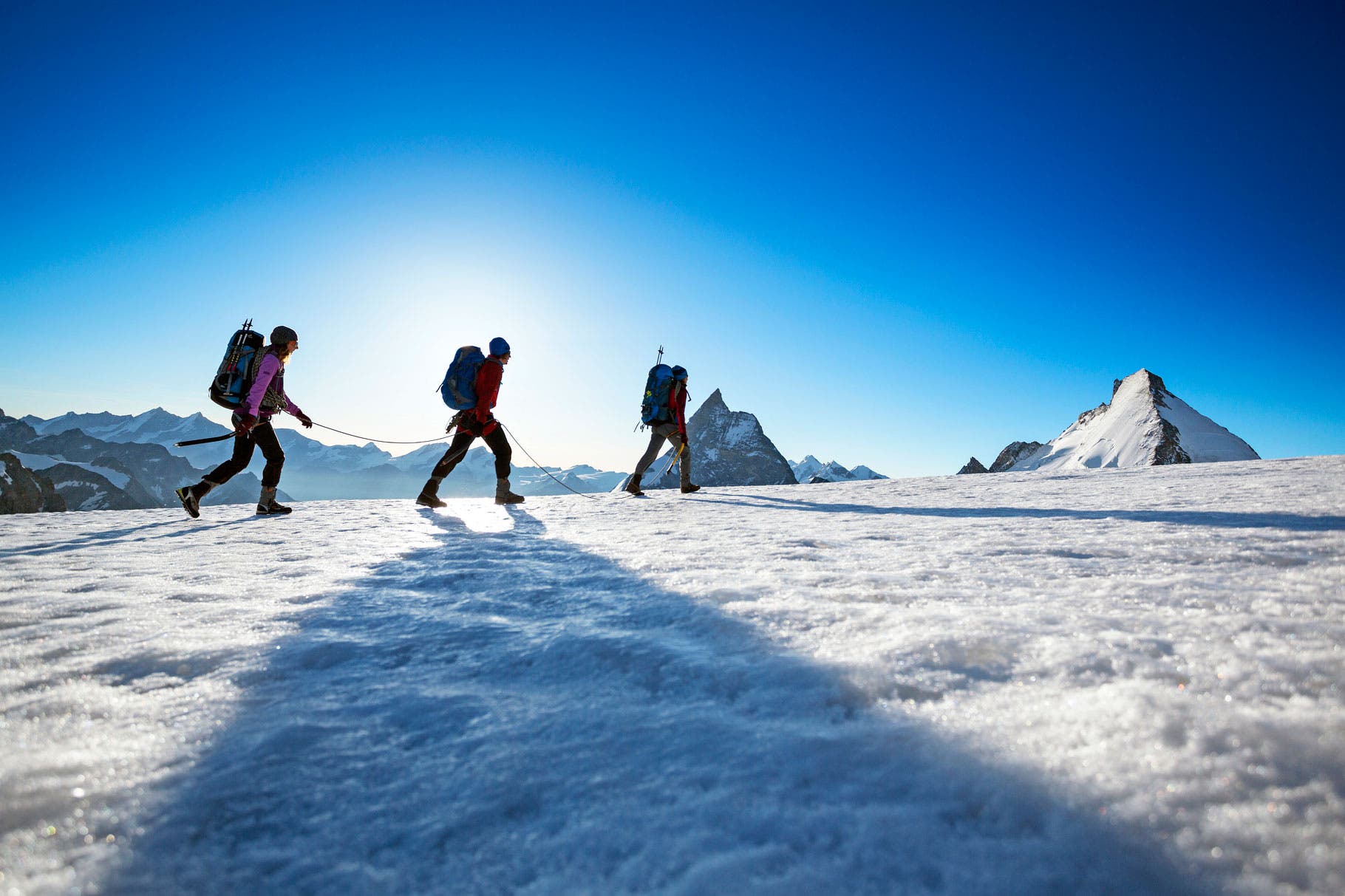 Three hikers climbing the final section of ridge to the summit of the Tete Blanche, a small, easy peak on the morning of the fifth day of the…