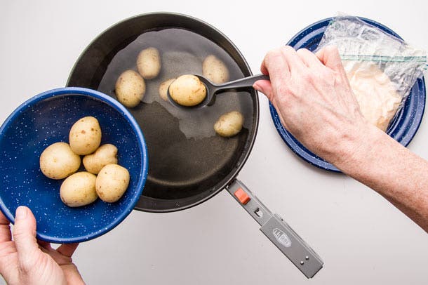 Scoop potatoes out of hot water