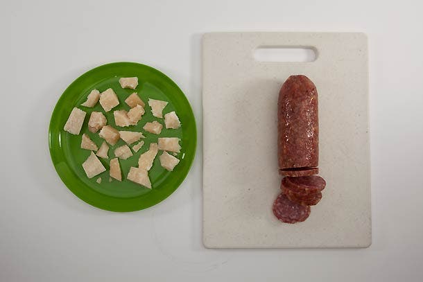 On a large plate, break cheese into half-inch chunks using a fork. Slice chorizo into bite-size pieces.