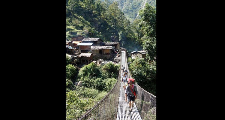 Crossing Budhi Gandaki Head guide Kalyan Gurung leads the way across the Budhi Gandaki on a modern suspension bridge on day four. (Dougald MacDonald)