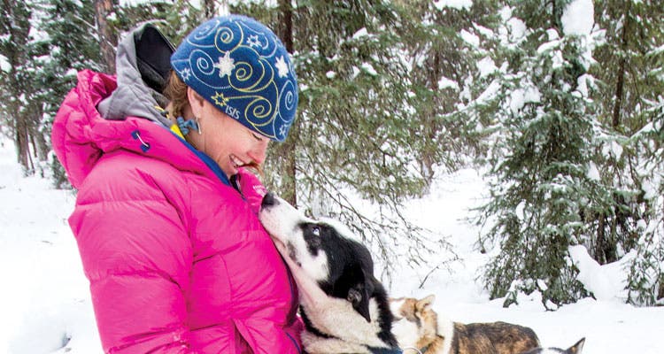 Molly Loomis and dog sled dog photo by Eric Lindberg