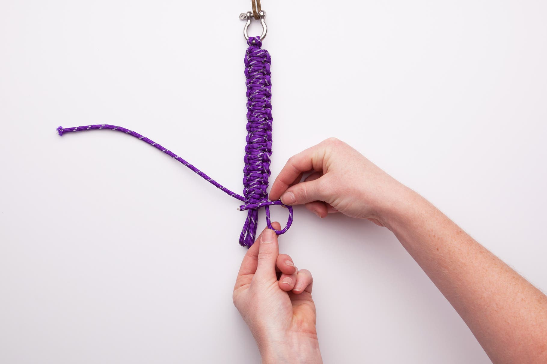 Knot until you have a little less than an inch of the middle cords showing. Now you will make the final knots to end the bracelet. To do this start…