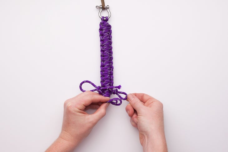 Make a Paracord Survival Bracelet 16 Now that you have a slipknot on each side, thread the two middle cords through the right slipknot.
