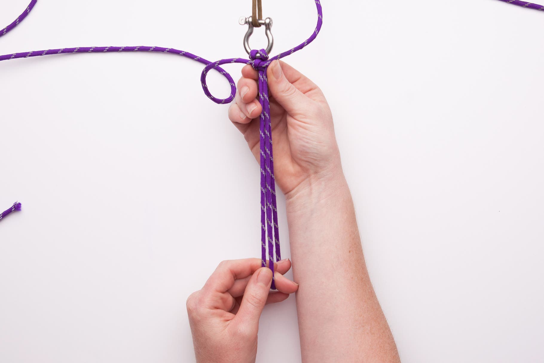 Make a Paracord Survival Bracelet 7 Pull both long cords tight. Push up the knots up toward the shackle.