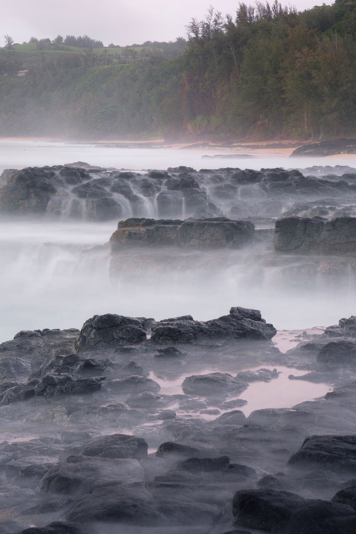 Mist shrouds the rocky pools of Secret Beach, one of the best Kauai hikes. 