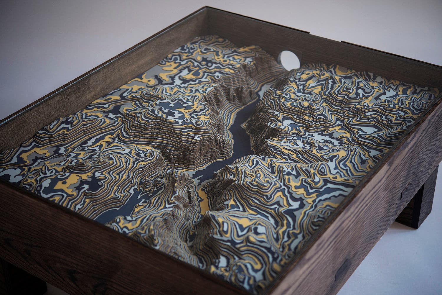 Topographic Yosemite map table. Blue, gray, and yellow layers stack up to create the landscape.