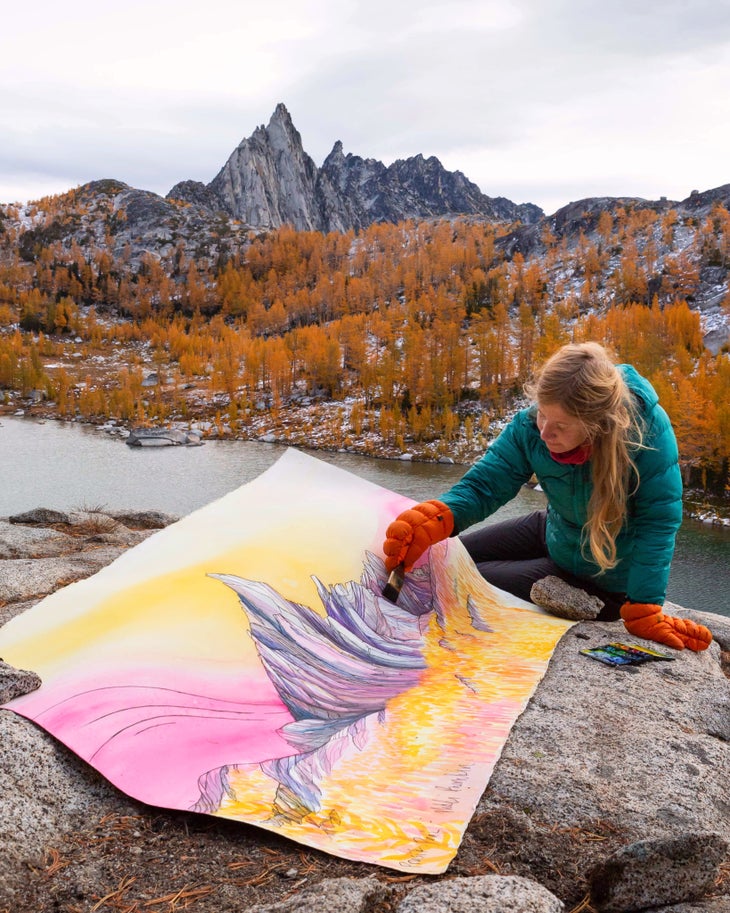 9 Prusik Peak (1) Nikki Frumkin sits on a rock painting Prusik Peak.
