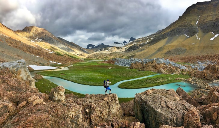 Premium Photo  Real hikers with a backpack on the trail mountain panorama  in spring or summer stones and grass