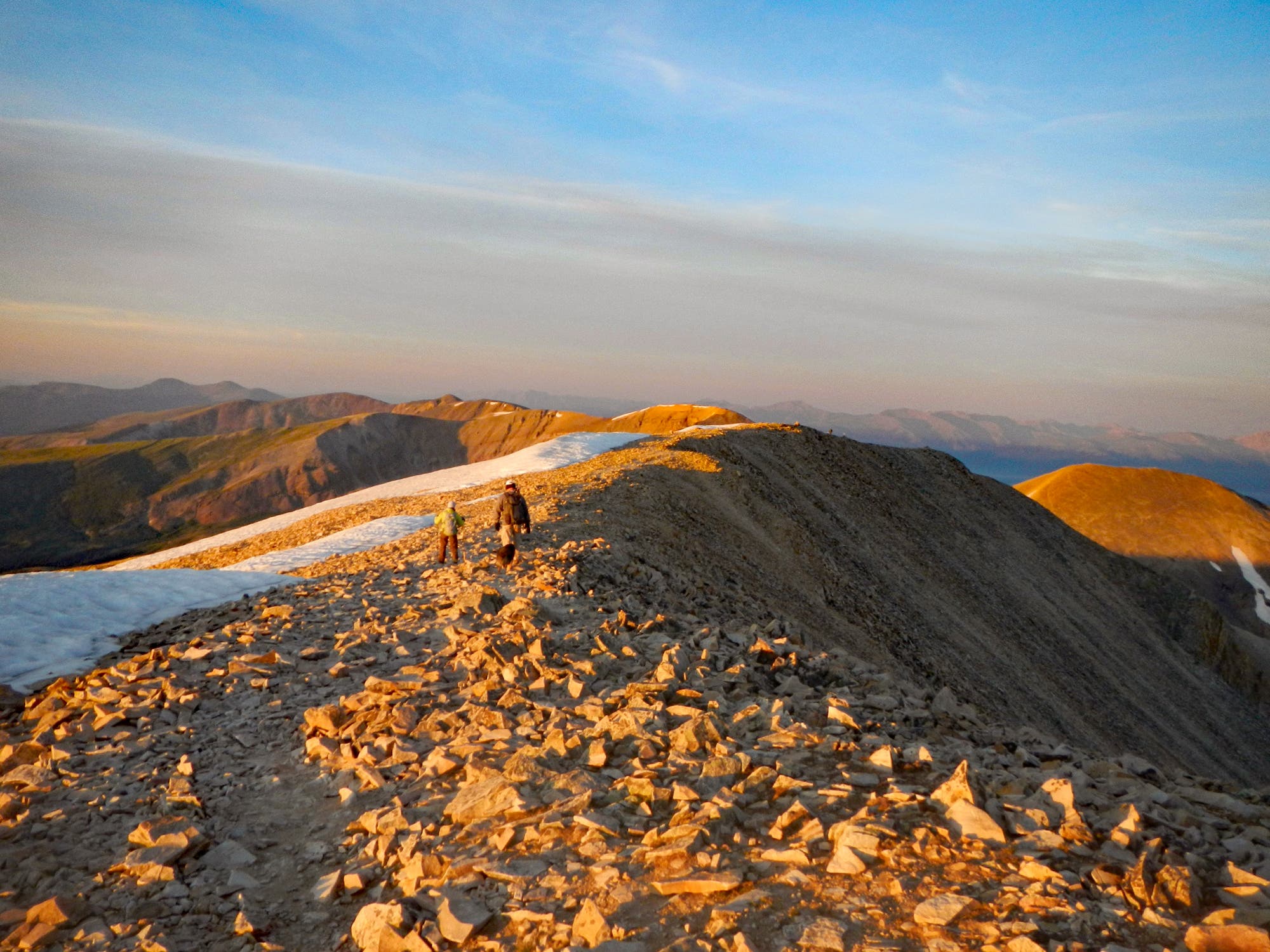 Hikers climbing a mountain in the morning sun. 