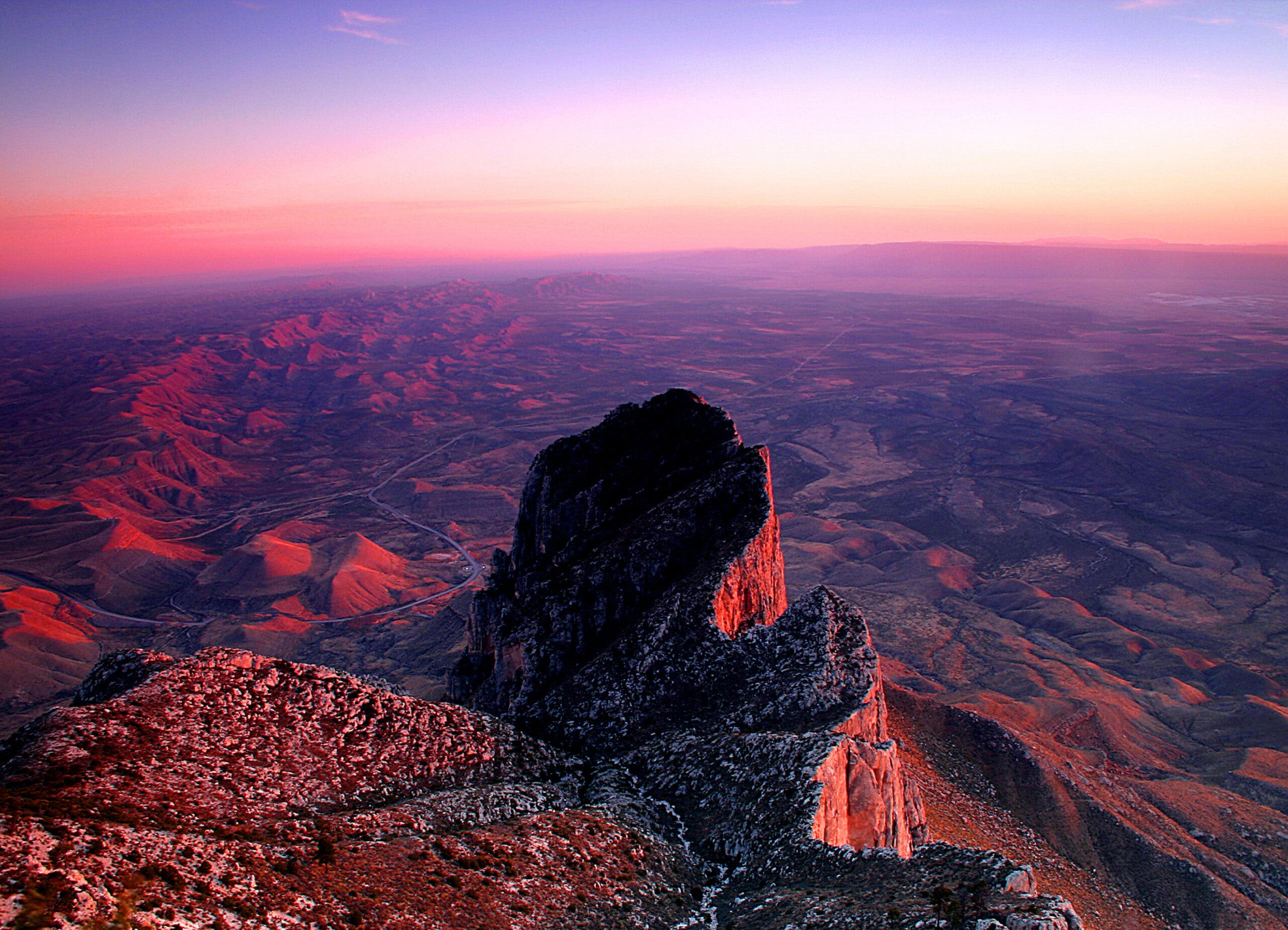 Sunset, Guadalupe Peak, Guadalupe Mountains National Park, Texas Soft purples and pinks fill the sky and cover the land around Guadalupe Peak, showing why it's one of the best sunrise (and sunset) hikes in the U.S.